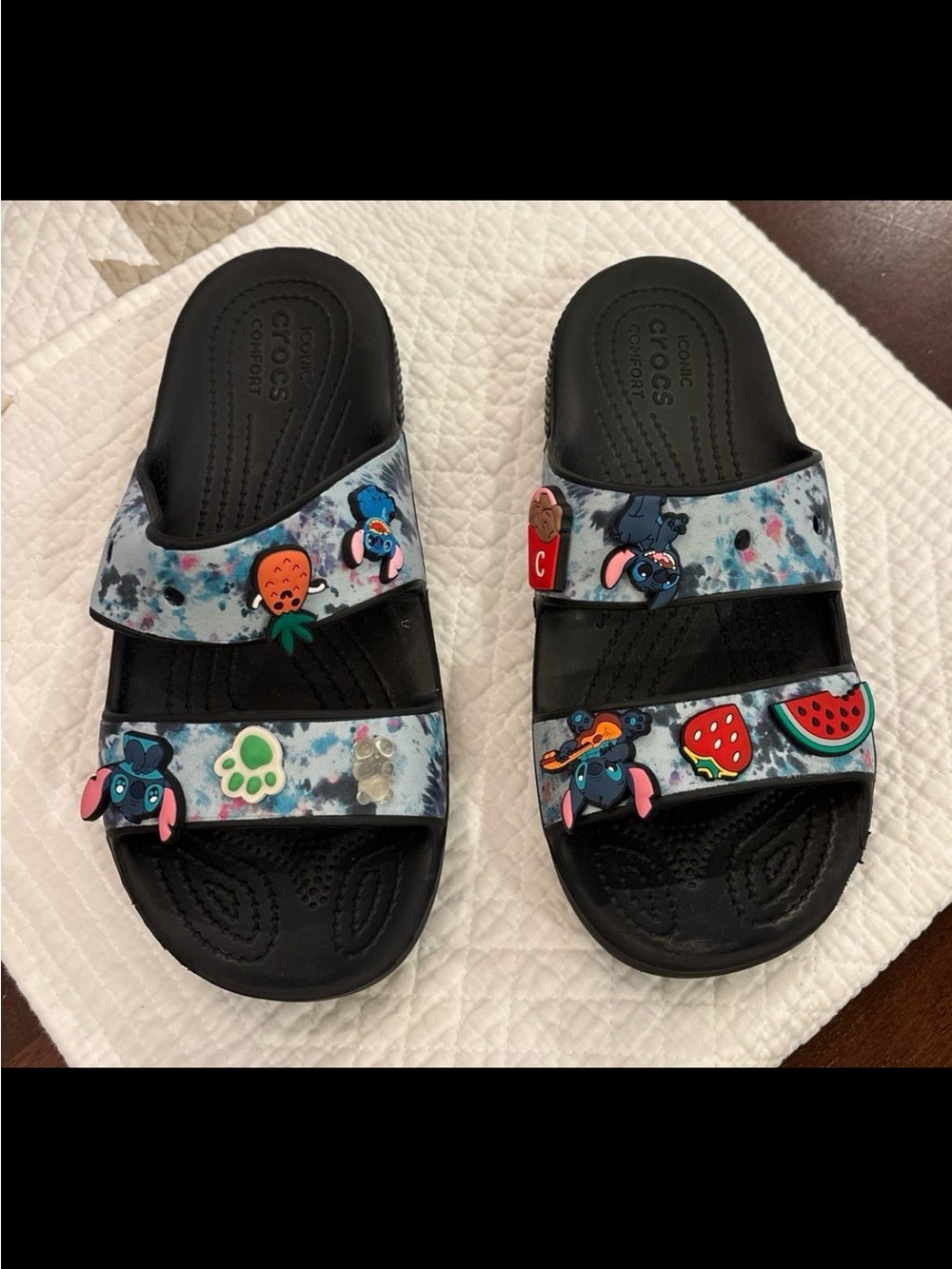 CROCS Kids Black Slide Sandals with Blue Tie-Dye Straps and Colorful Charms